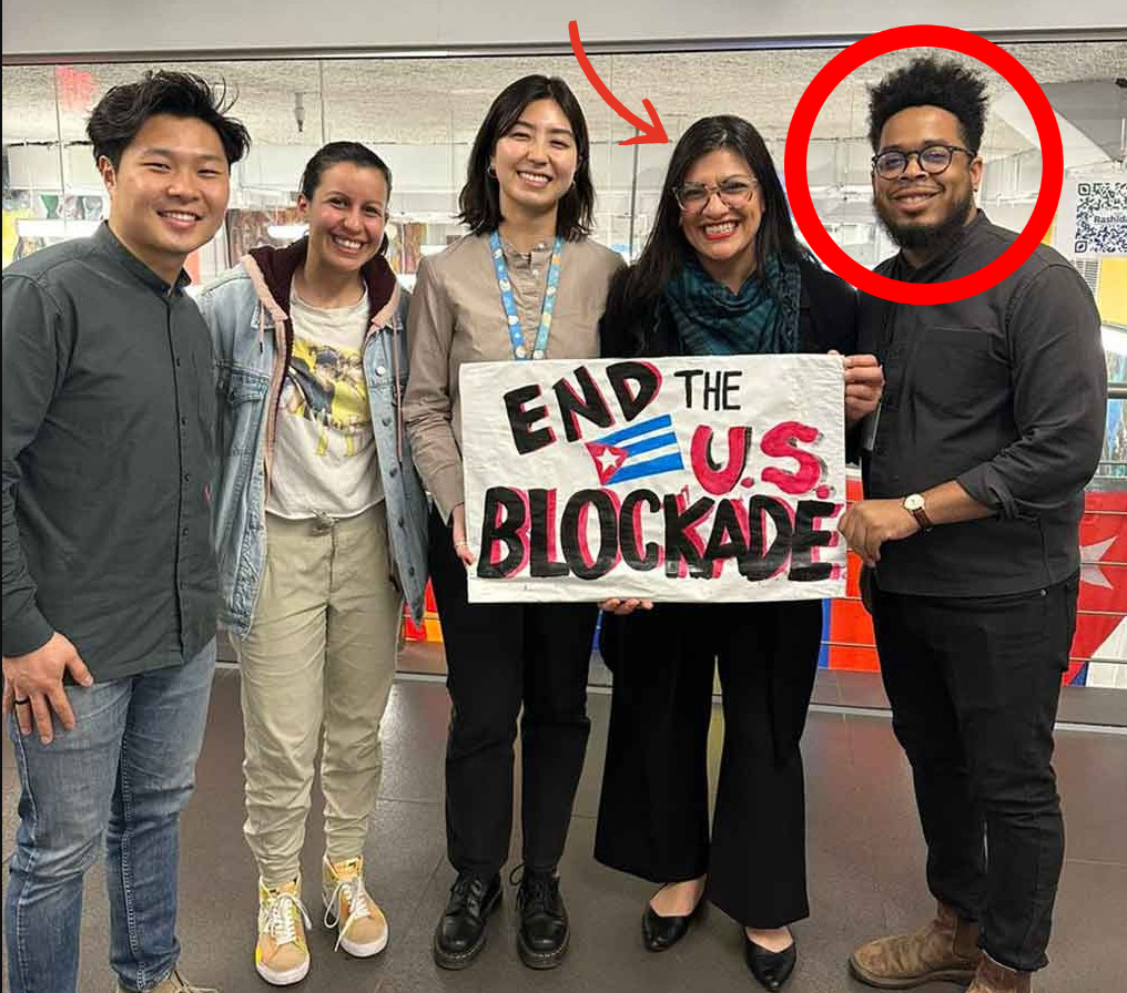 Manolo De Los Santos with Rep. Rashida Tlaib holding END THE U.S. BLOCKADE sign, March 2023